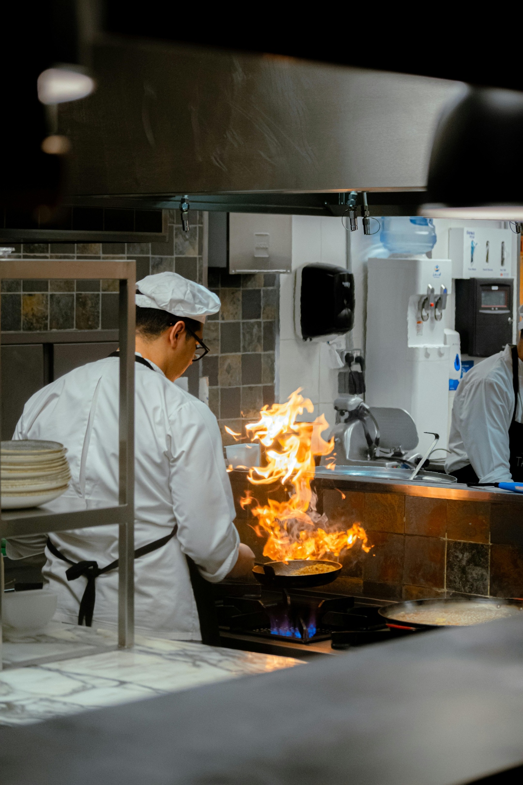 Bếp trưởng đang chế biến món ăn với ngọn lửa
